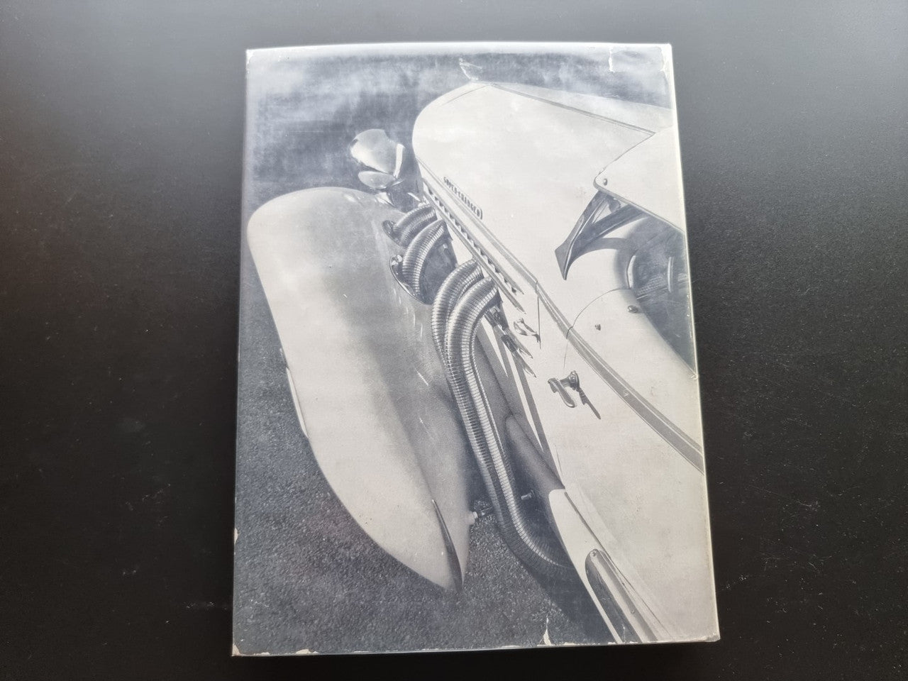 Vintage car photo page featuring a close-up of a classic engine and fender