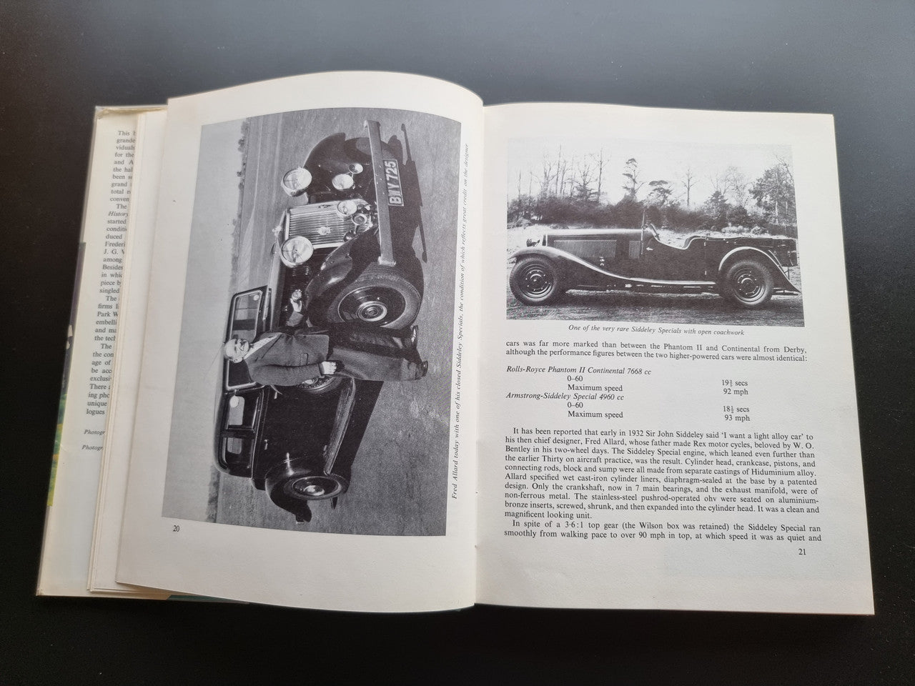 Classic car history book open with two black-and-white car photographs and captions