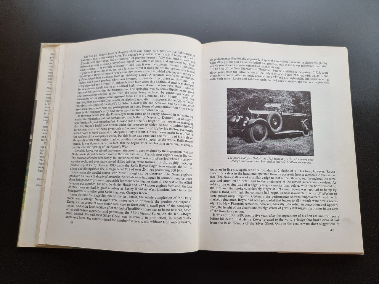 Classic car history book open spread with text and a small vintage car photo