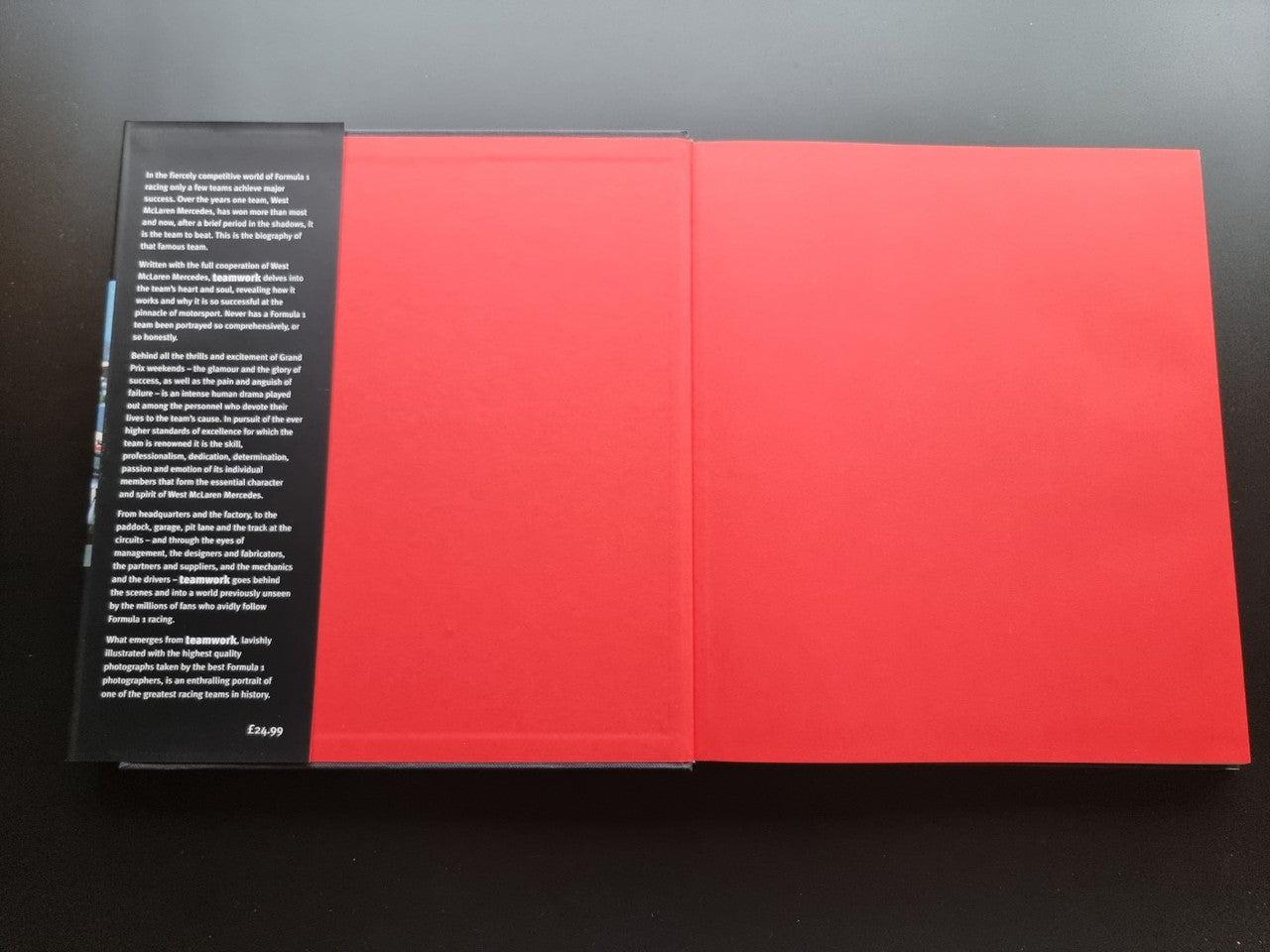 Open book with red pages and dense black text column on the left