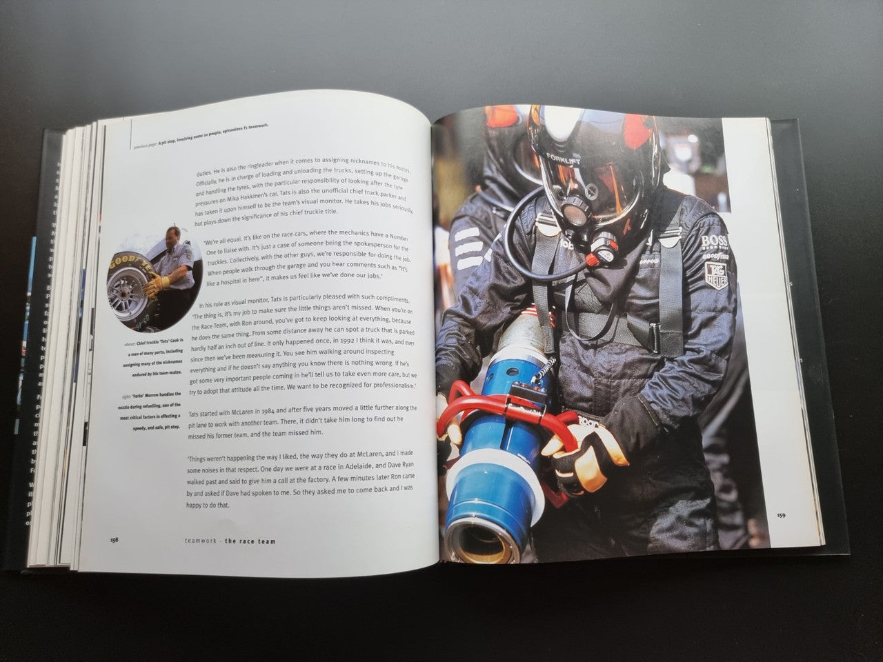 Open biography book showing a race mechanic holding an engine component photo