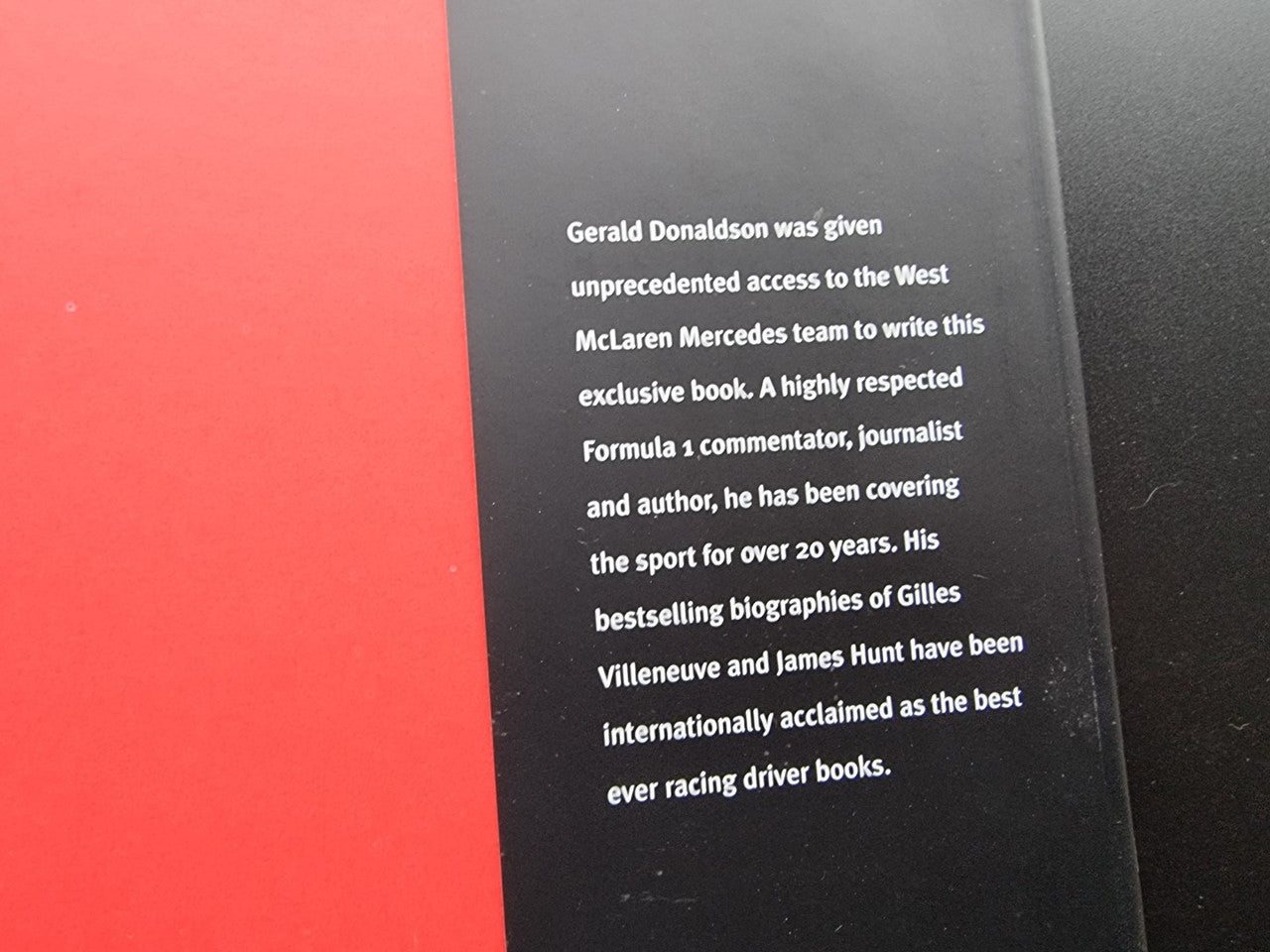 Closed book cover with black panel and white biography text on the right