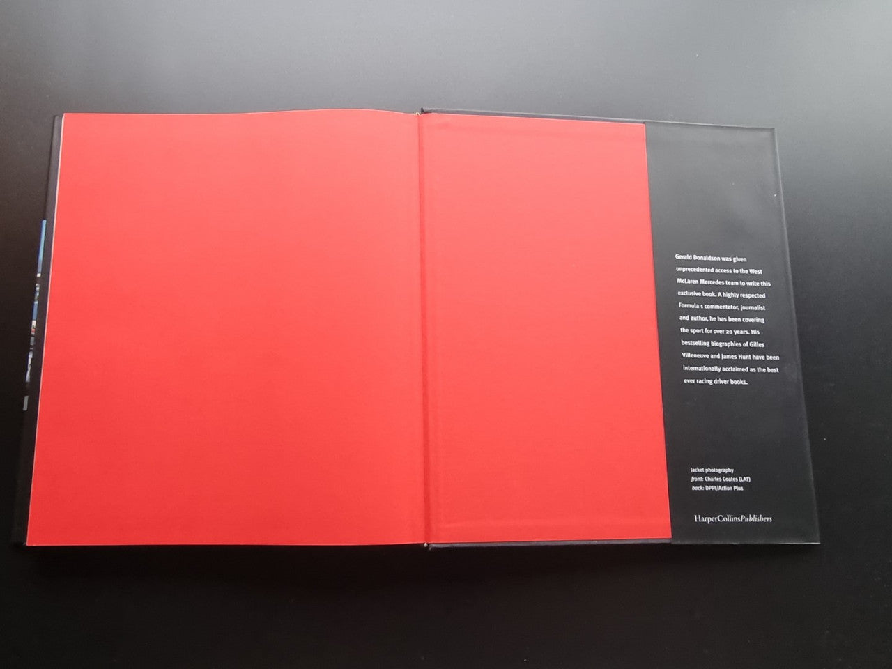 Open book with red inside pages and a small black text block on right