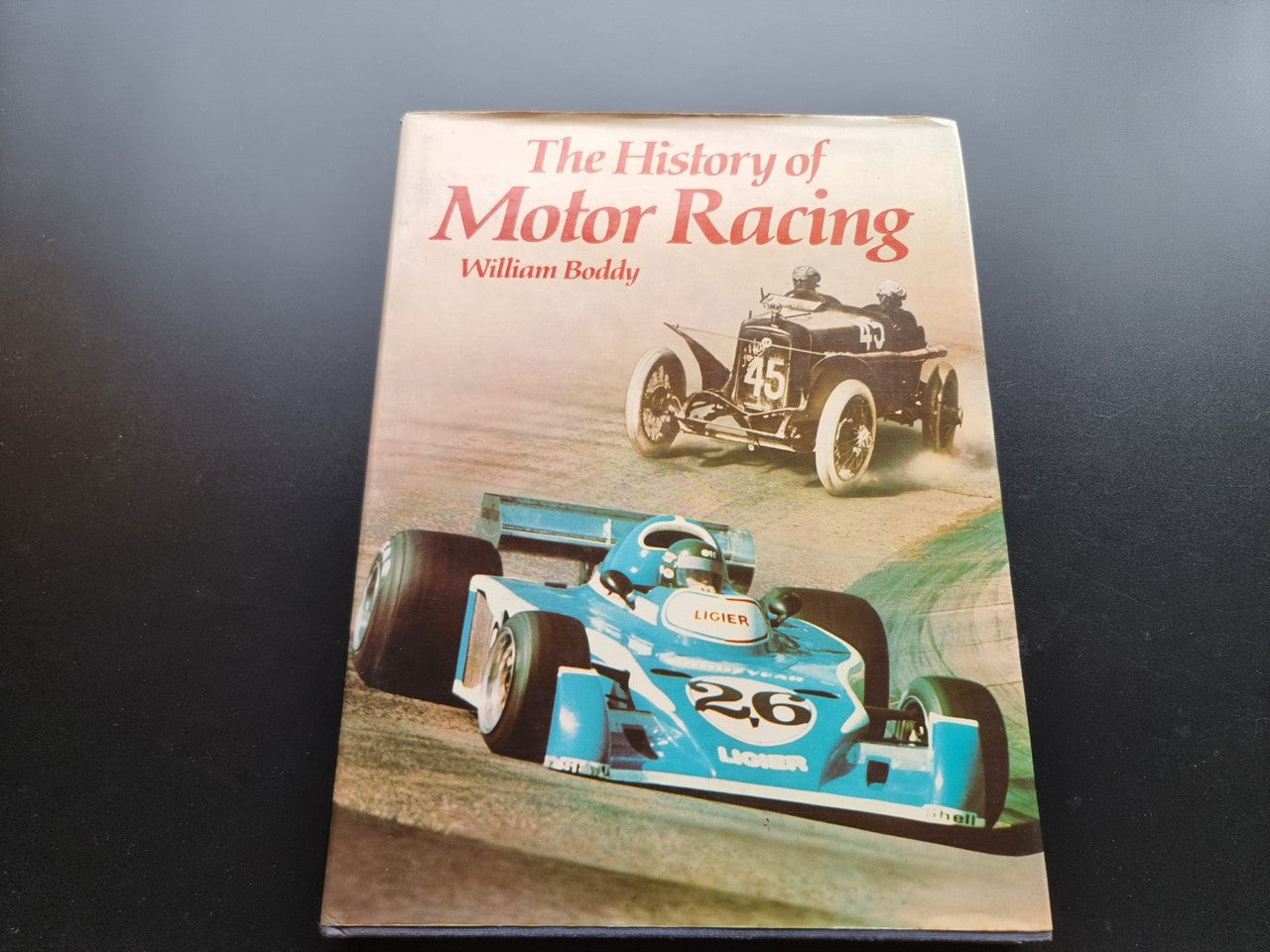 Motor racing history book, tan cover with vintage race cars and author name
