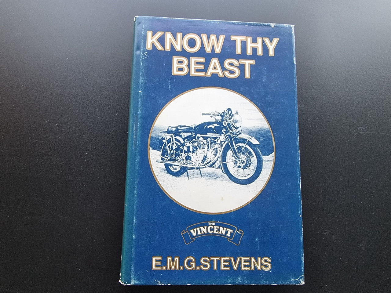 Blue book cover with 'Know Thy Beast', motorcycle graphic, and E.M.G. Stevens name