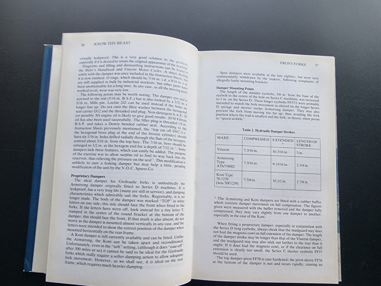 Motorcycle workshop book open to technical pages with a table and headings