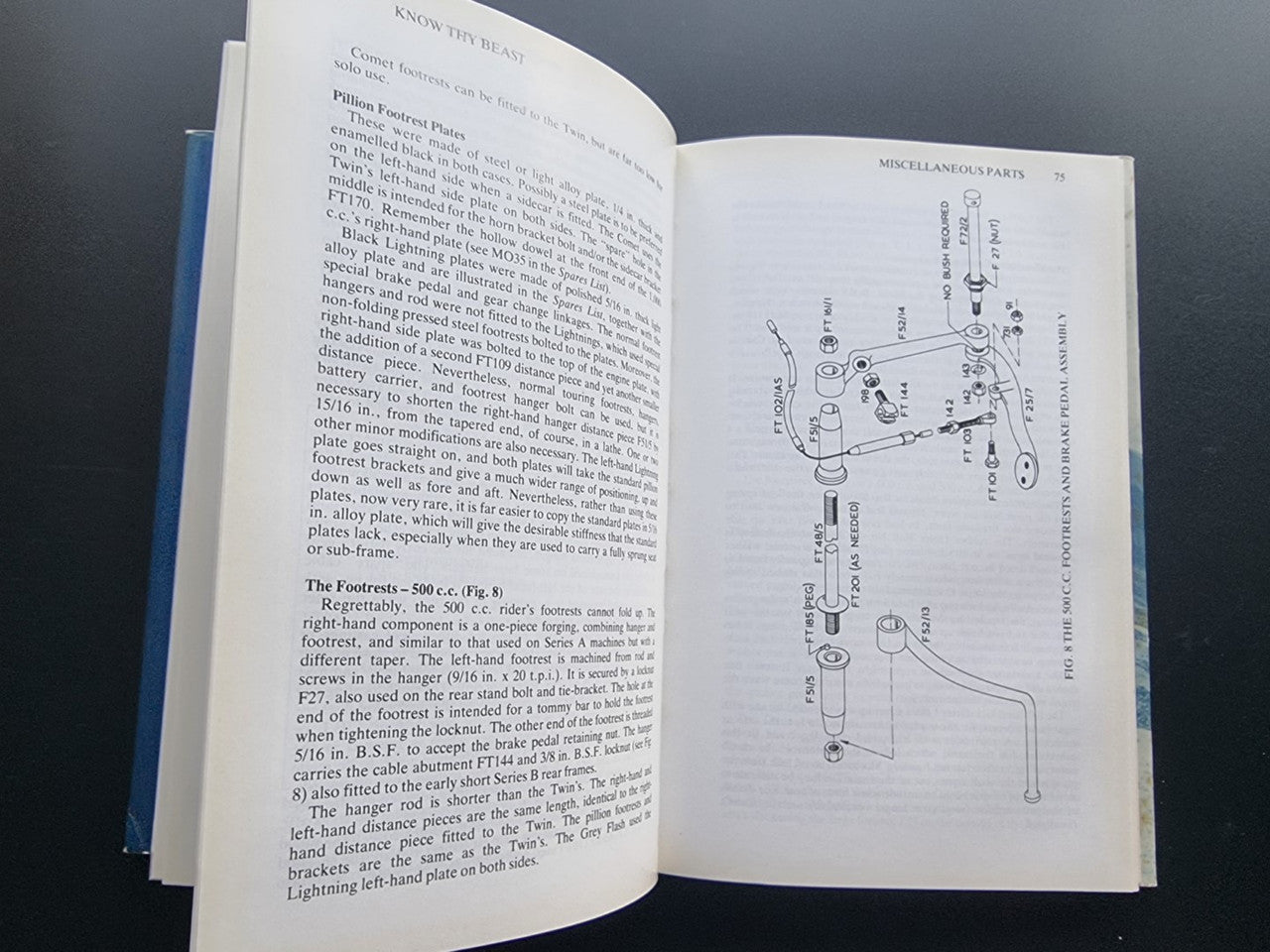 Motorcycle workshop book opened to technical text and wiring diagram pages