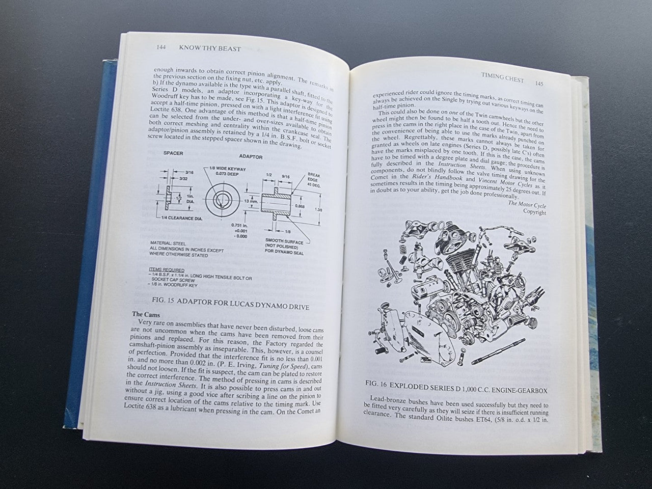 Motorcycle workshop book opened to diagrams and a detailed engine illustration