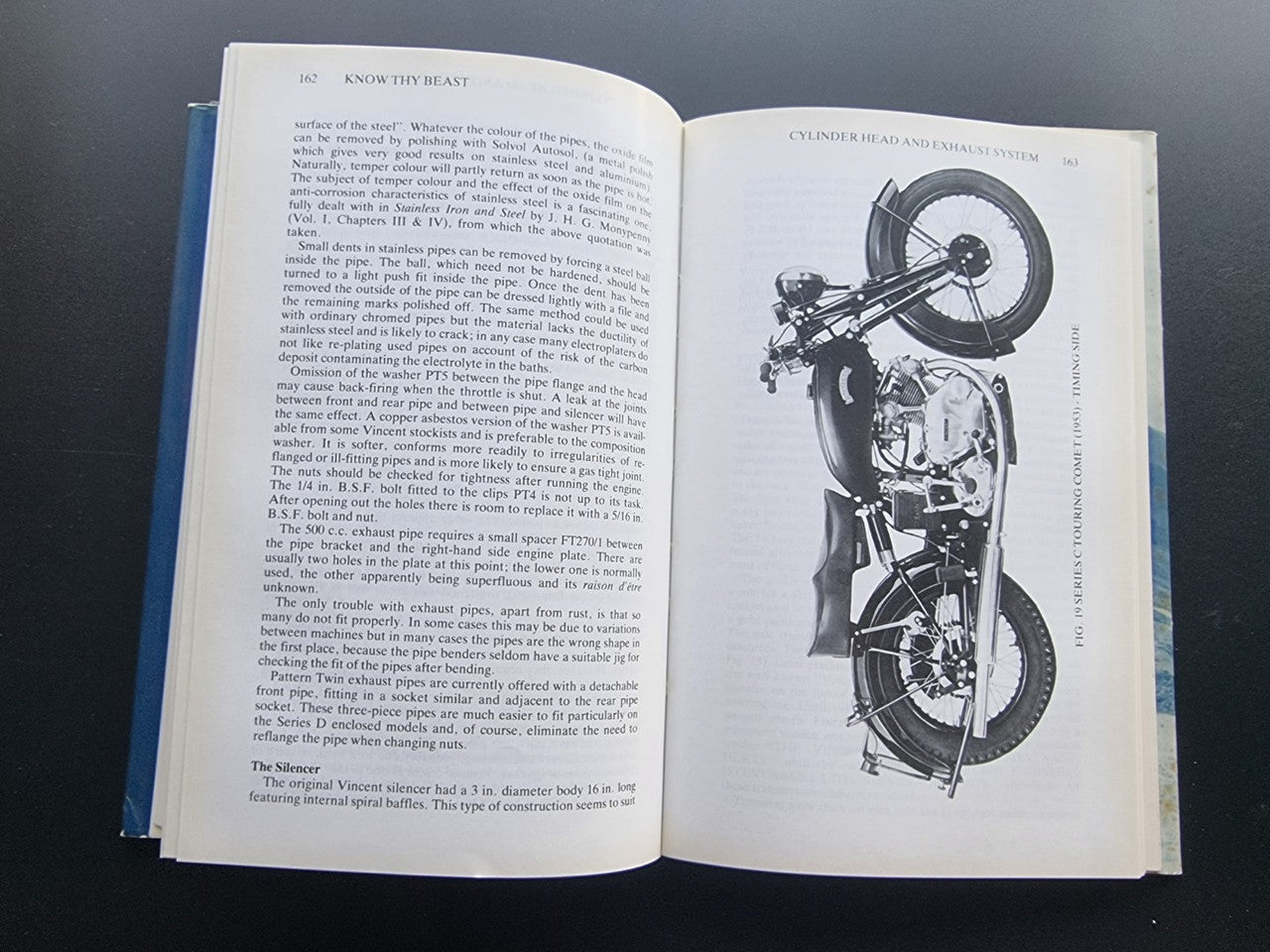 Motorcycle workshop book open to an engine assembly illustration with surrounding text