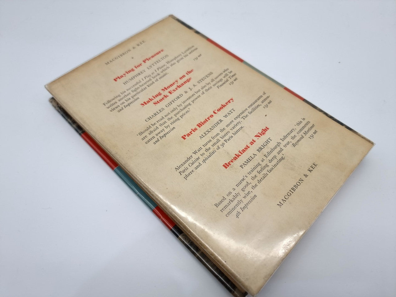 Vintage motorsport book with beige cover, small text, and red spine edge