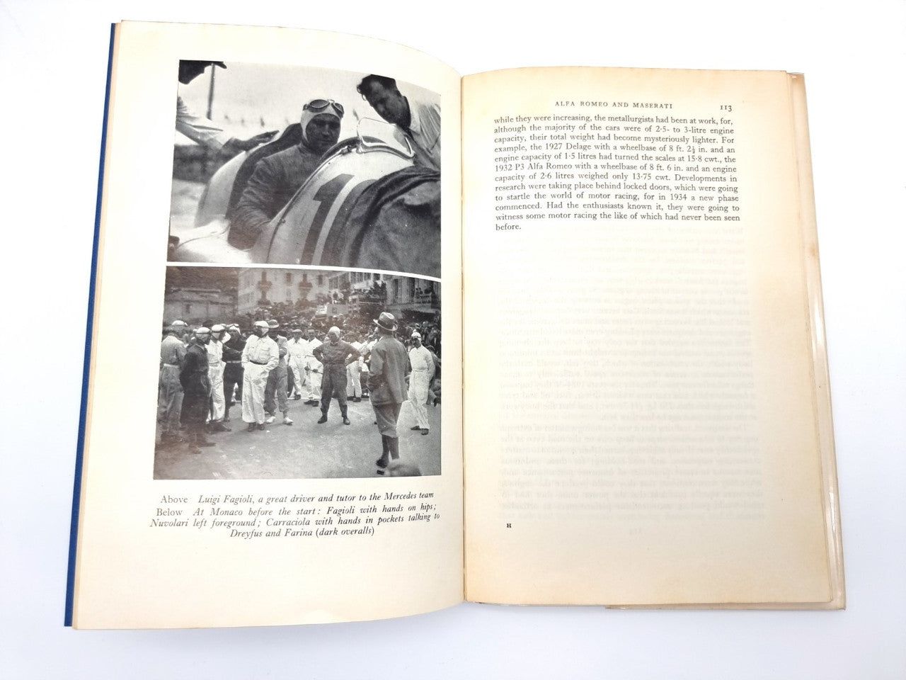 Vintage motorsport book open, spread with black-and-white race photos and captions