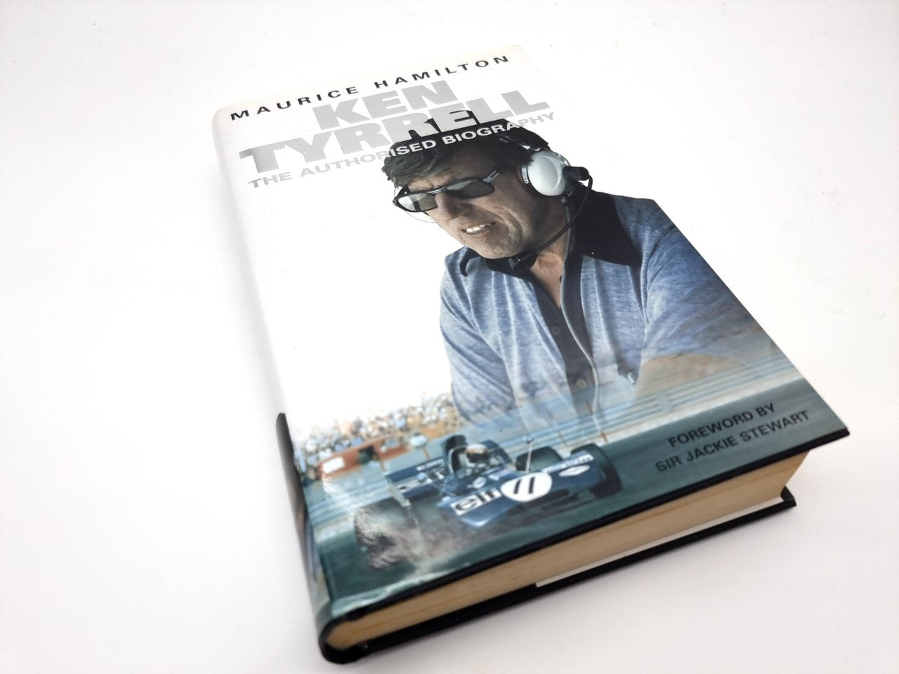 Motorsport biography book angled, showing front cover title and headset portrait