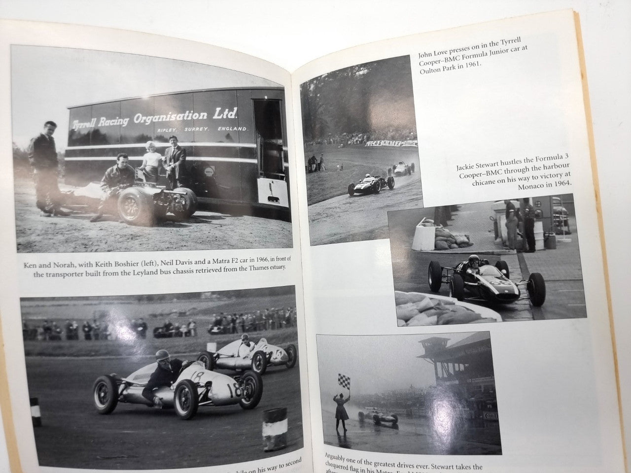 Book open to black-and-white racing photo pages with caption text