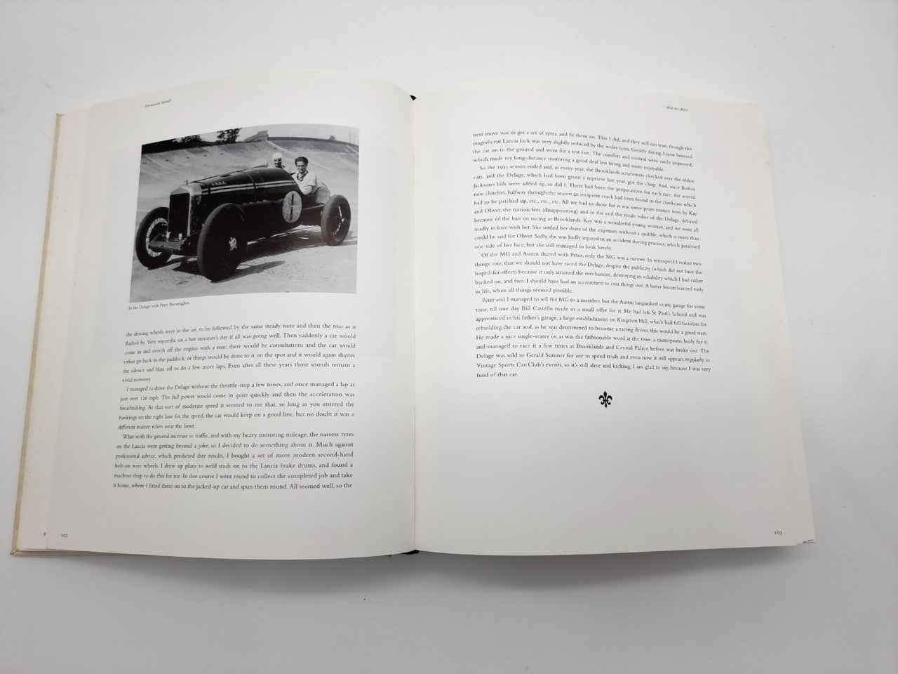 Open portfolio book with vintage car photo and dense printed text