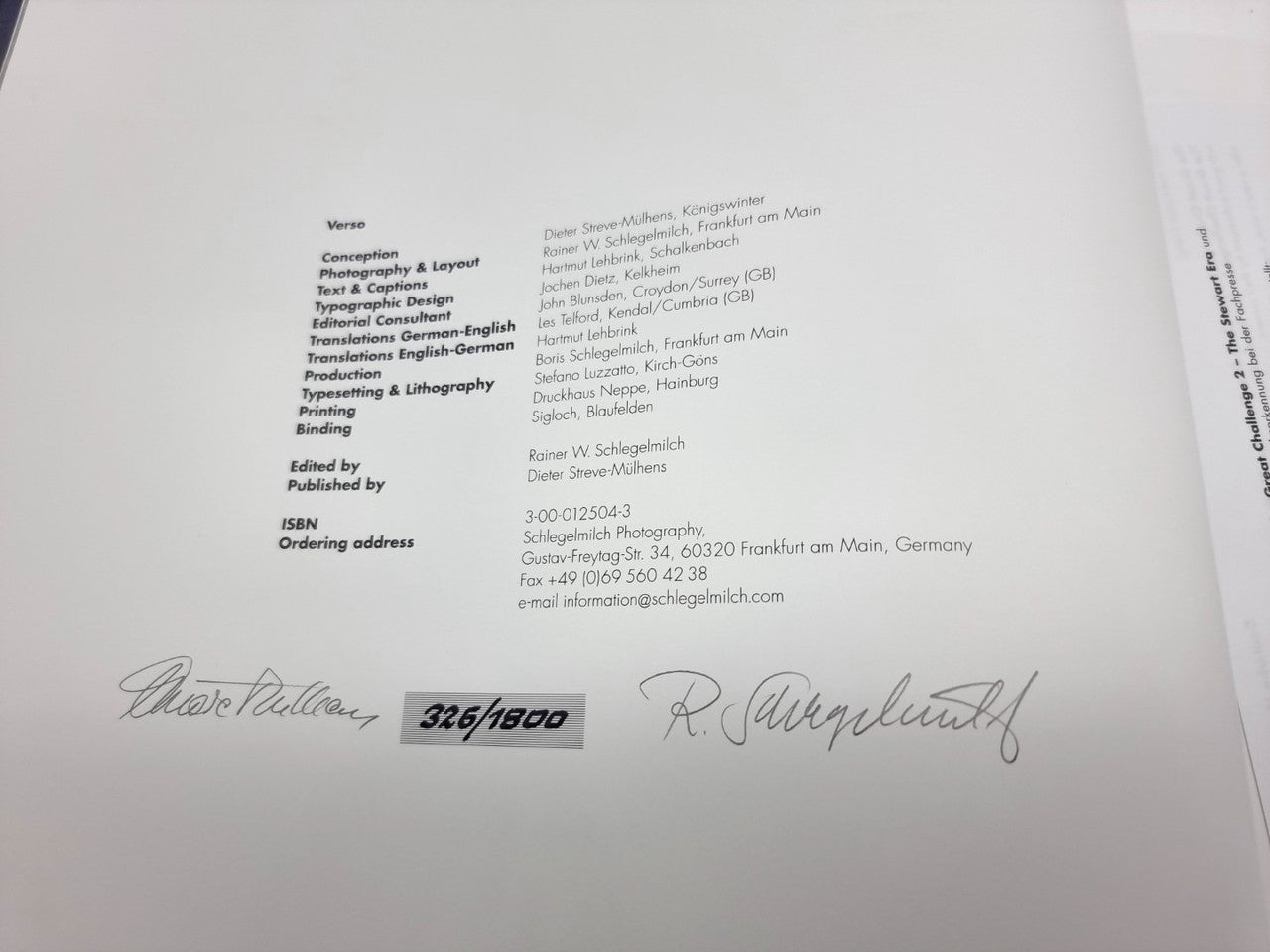 Motorsport book pages with printed credits and two handwritten signatures