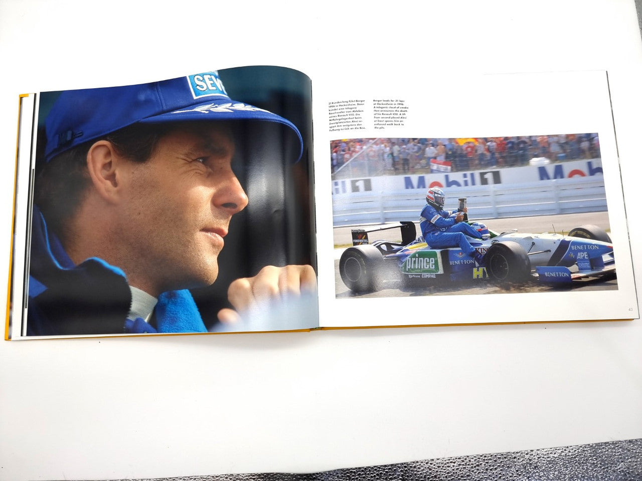 Open motorsport book showing driver portrait and race car photo spread