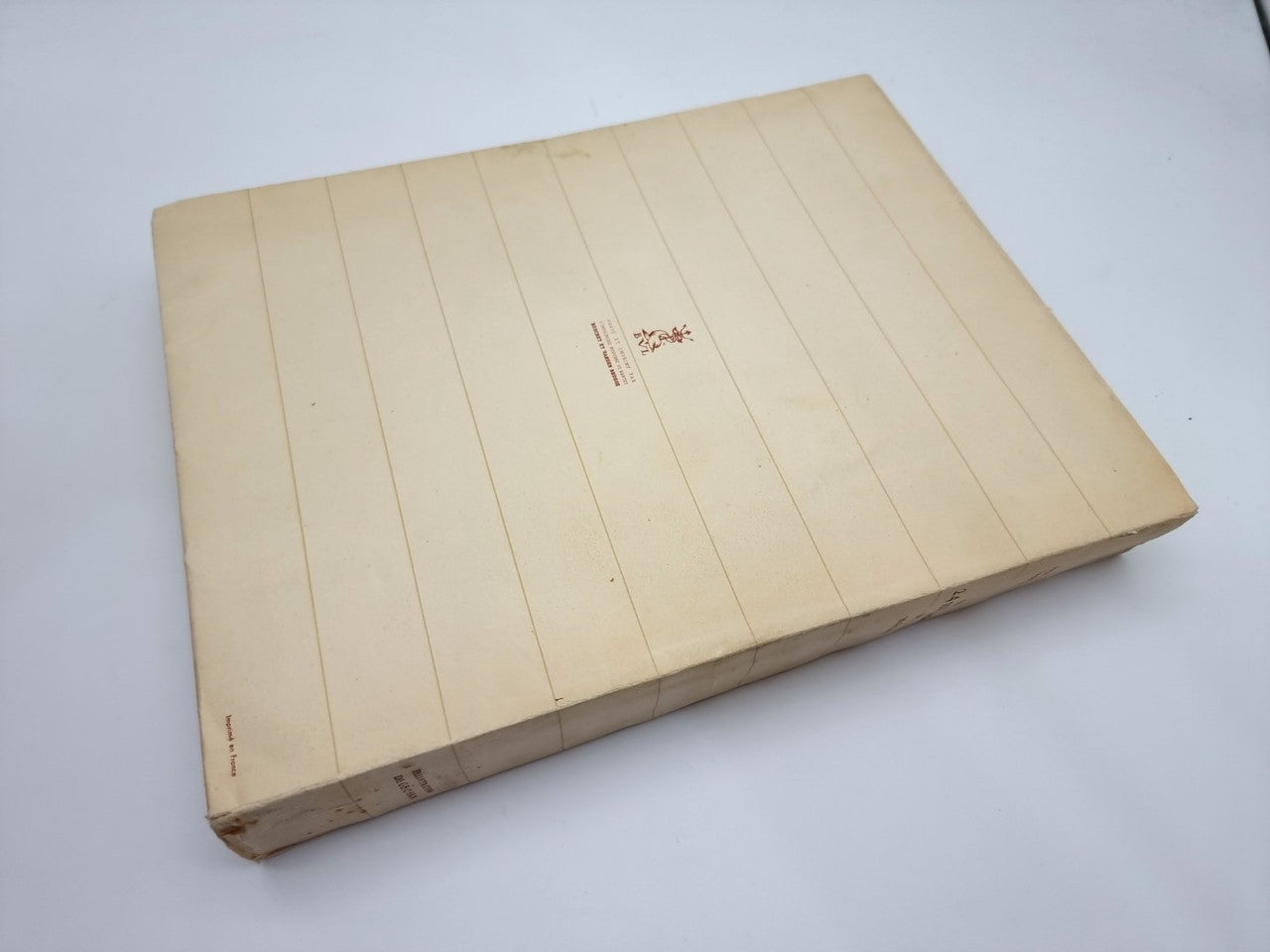 Closed beige book with small logo emblem centered on front cover