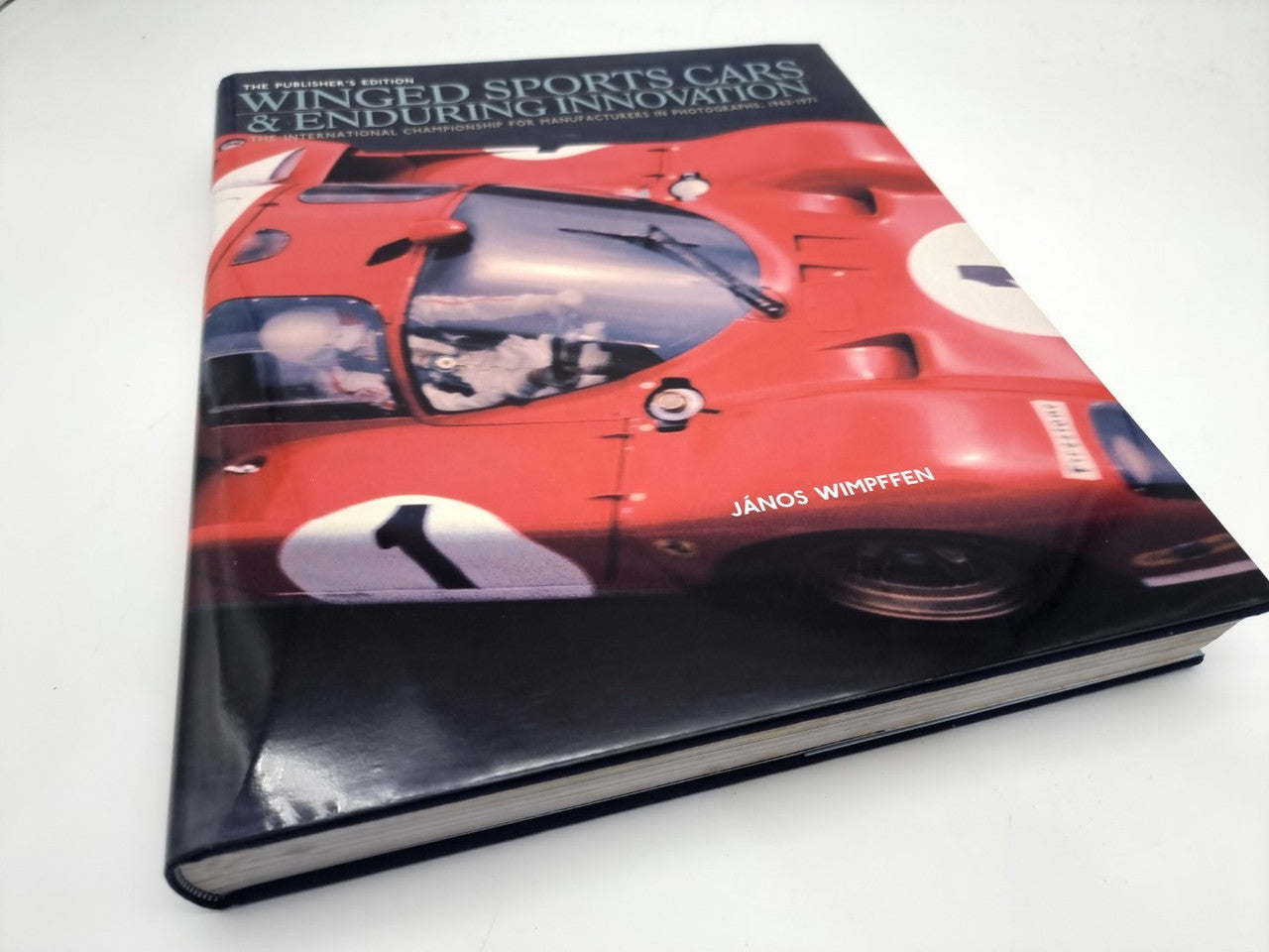 Hardcover book with red sports car cover art and title text, glossy finish
