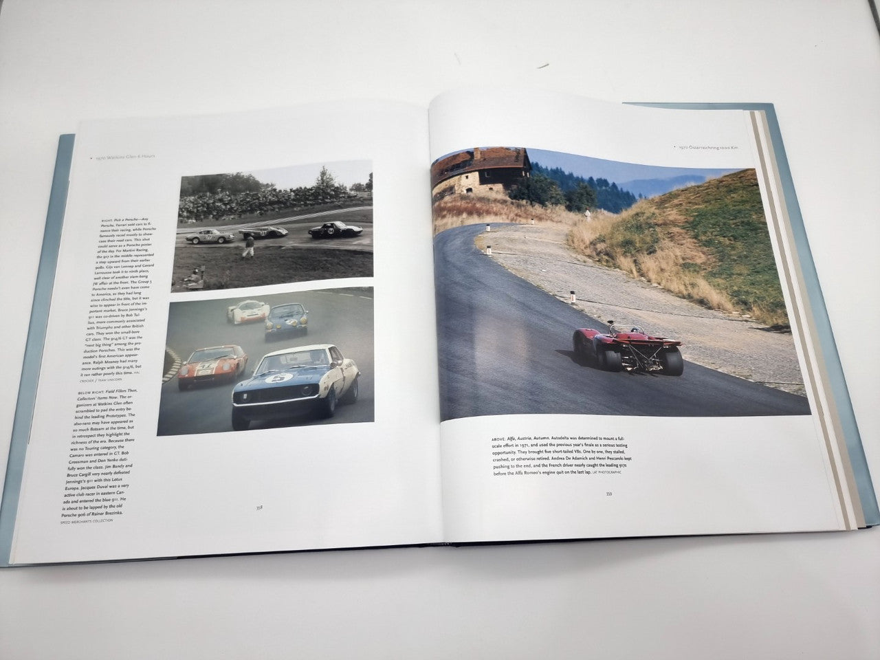 Signed hardcover book open to car photo pages with winding road and classic sports cars
