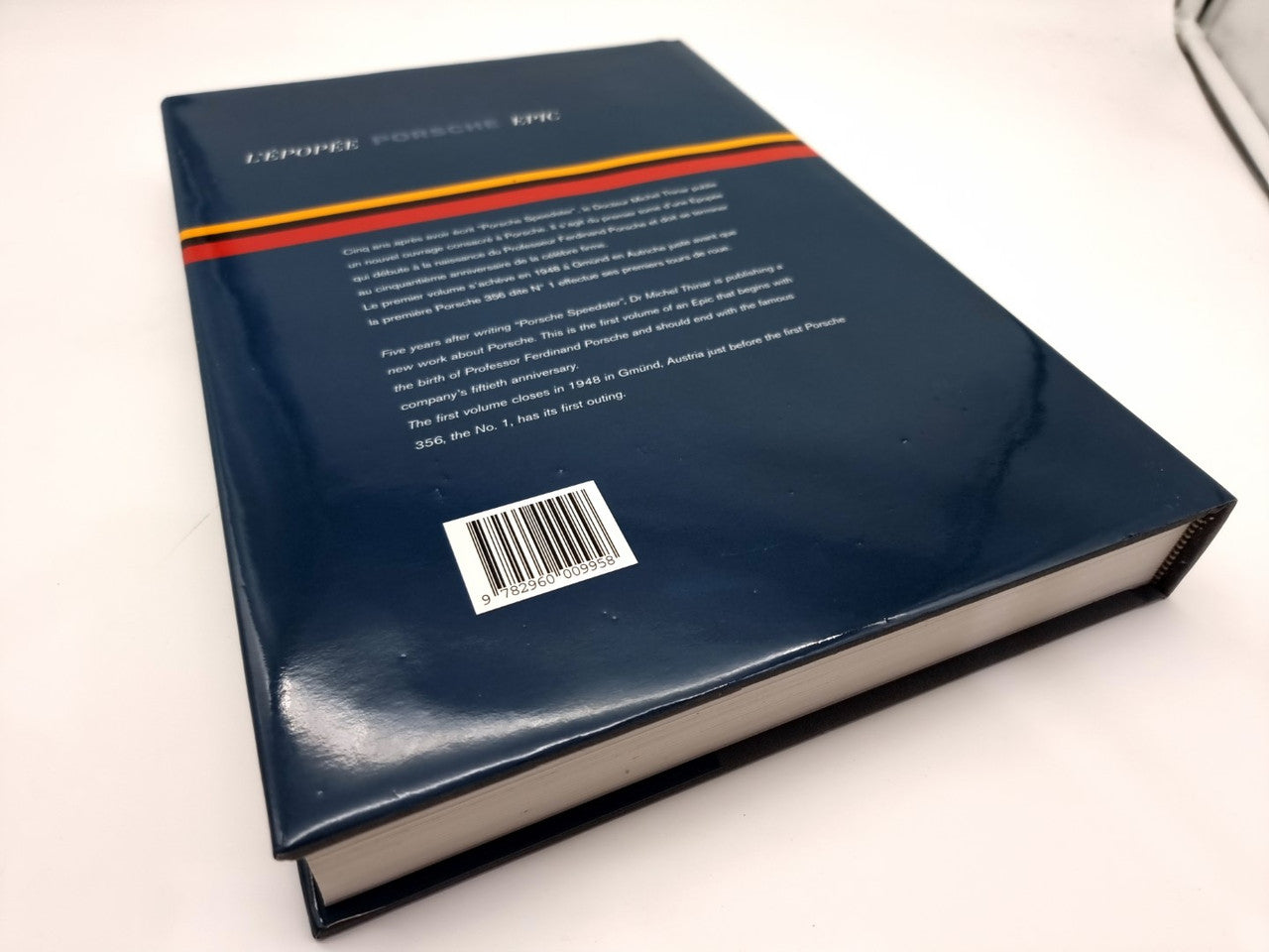 Blue hardcover book with orange and red stripe detail and barcode sticker on cover