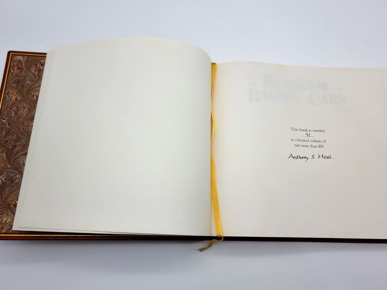 Open brown leatherbound book with cream pages and yellow ribbon bookmark