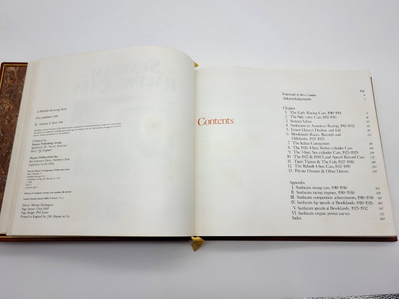 Open brown leatherbound book showing Contents page and surrounding text