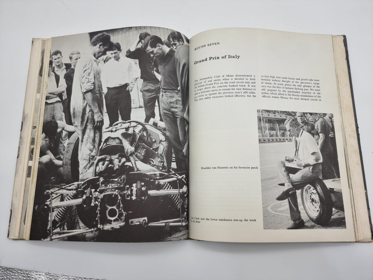 Vintage racing book open to race photo spread, including car engine close-up
