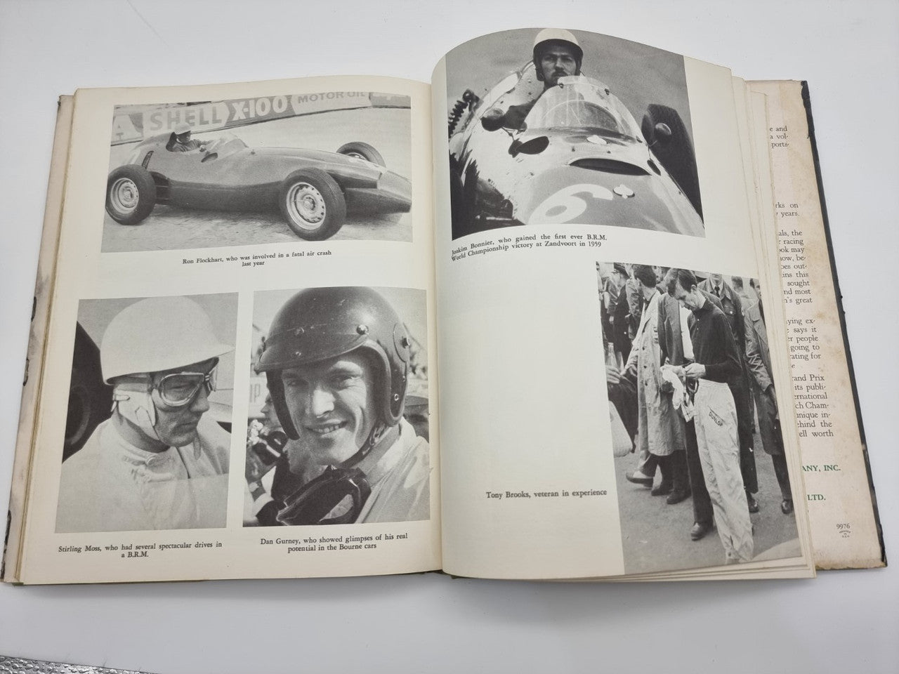 Vintage racing book opened to car and driver photo pages with printed captions and text