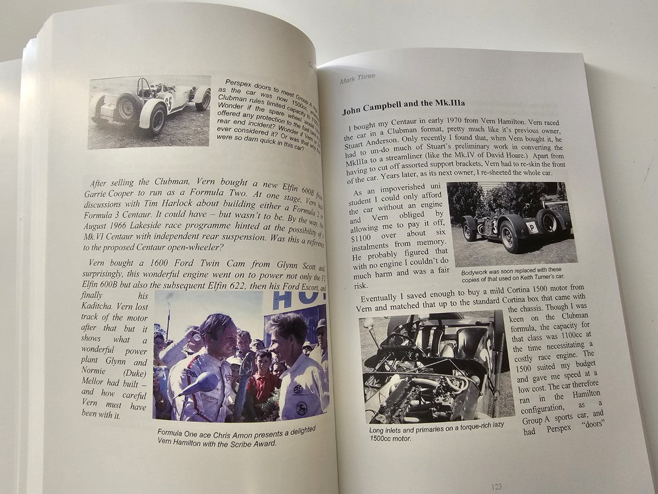 Signed motorsport history book, open spreads with vintage car photos and captions.