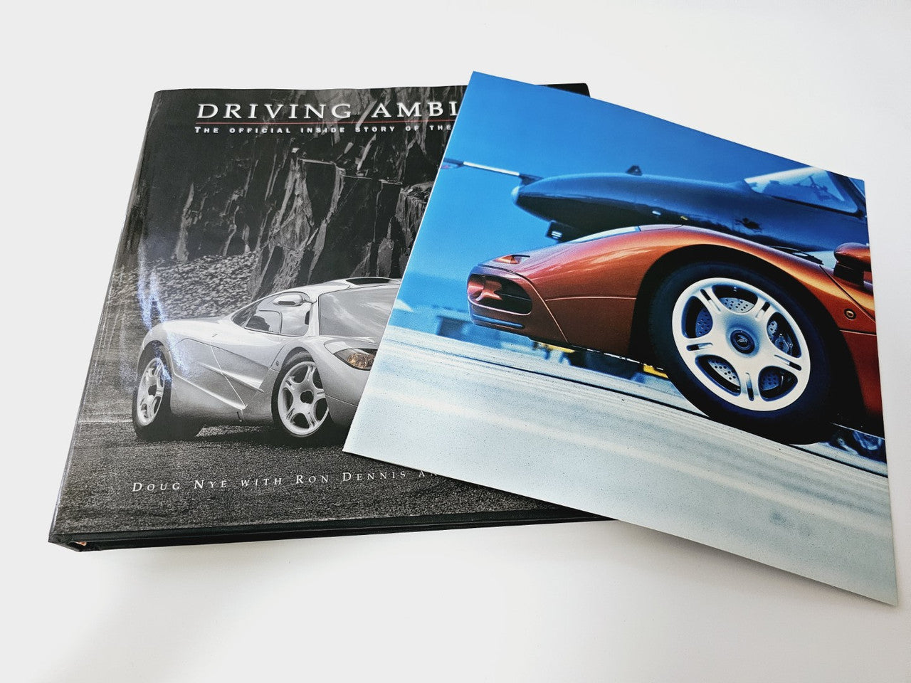 Stacked books with a black hardcover cover and a blue car photo cover