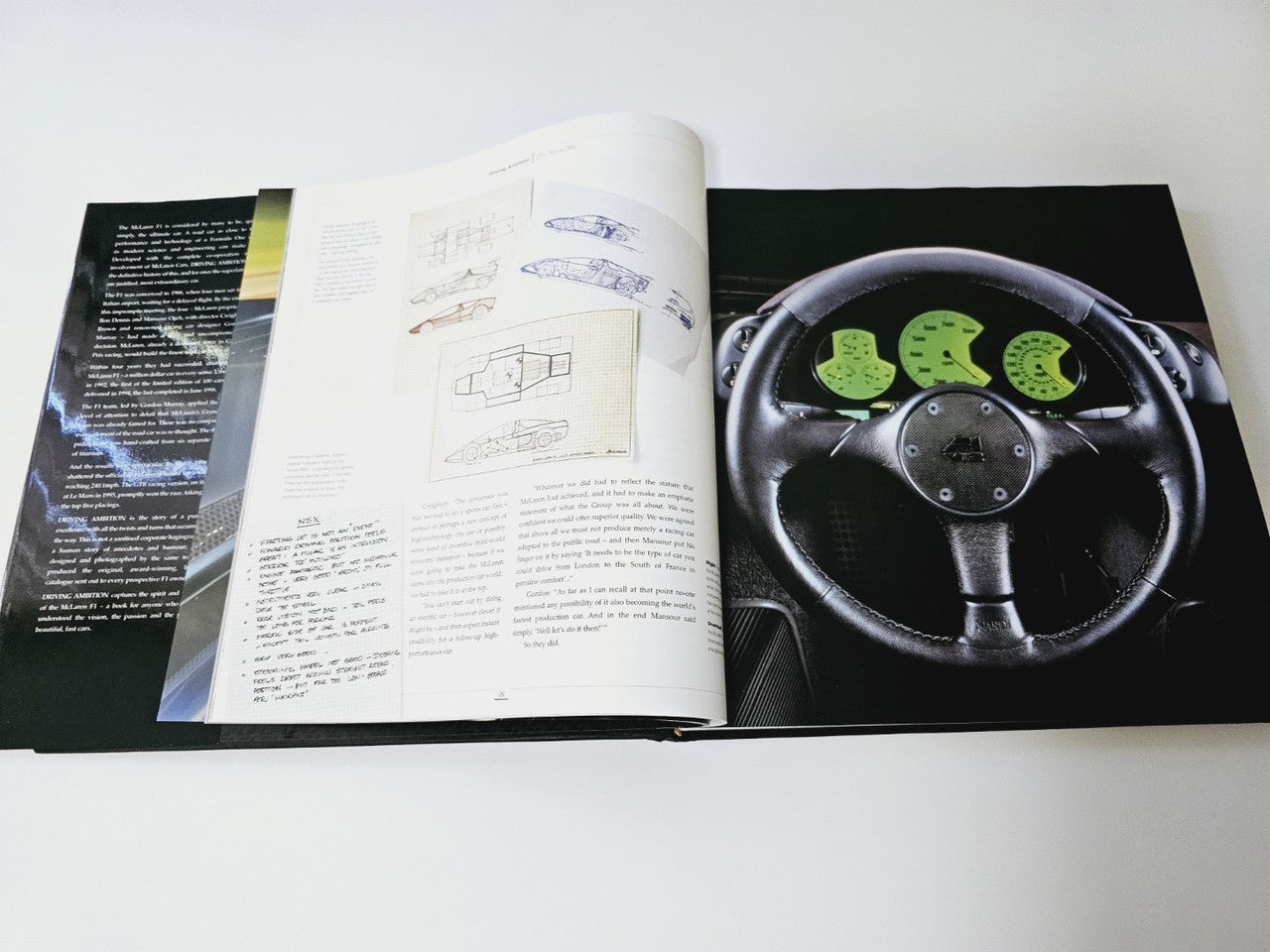 Open book with technical diagrams and a close-up photo of a steering wheel