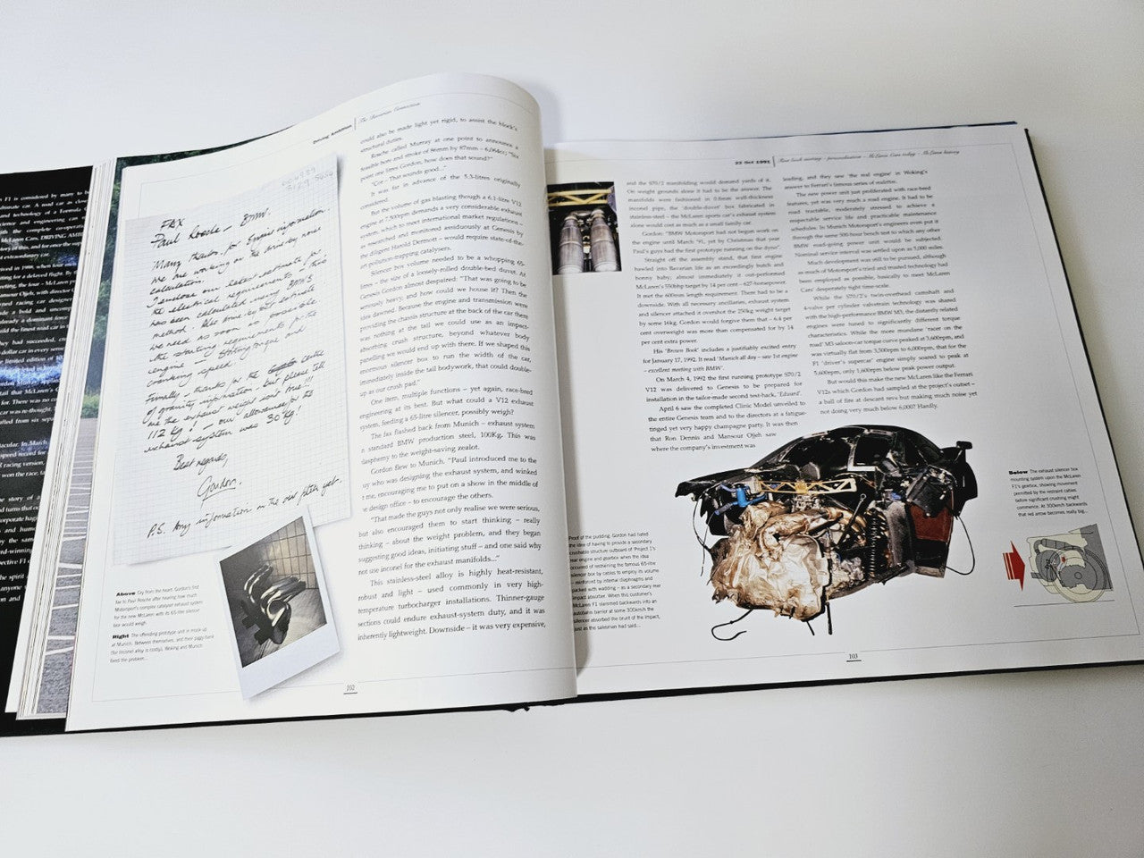 Open book with handwritten notes and a detailed car component photo