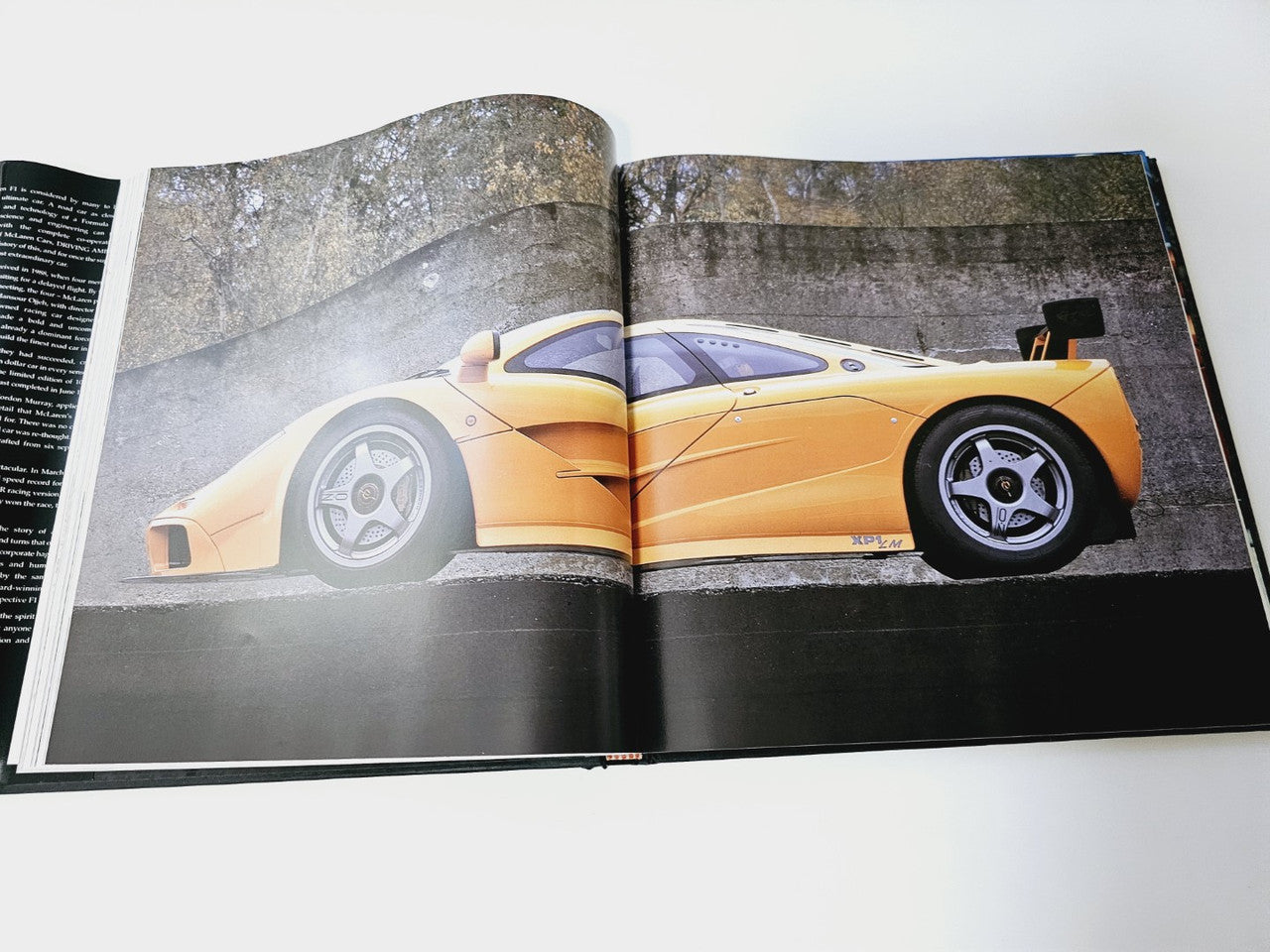Open book with photo spread of a yellow race car on track