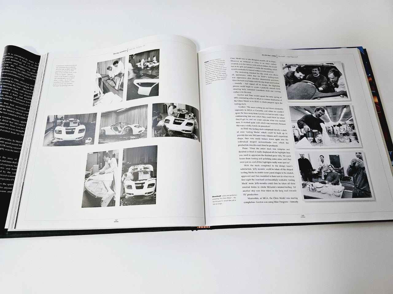 Open book showing black-and-white car photo pages with captions