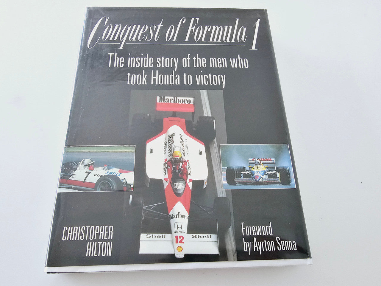Hardcover book cover titled Conquest of Formula 1 with race car graphic