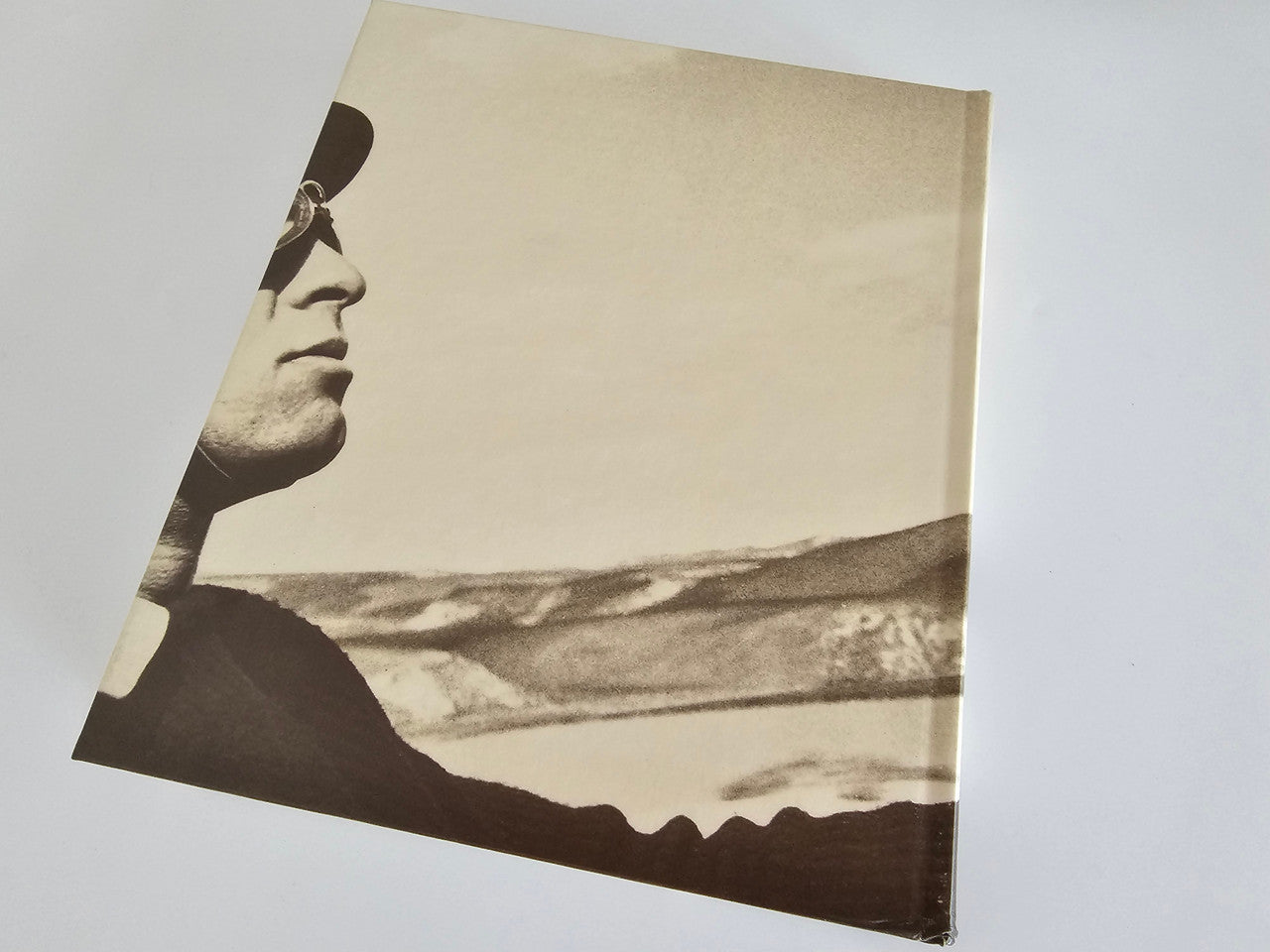 Ferrari racing book cover with black-and-white portrait and landscape scene.