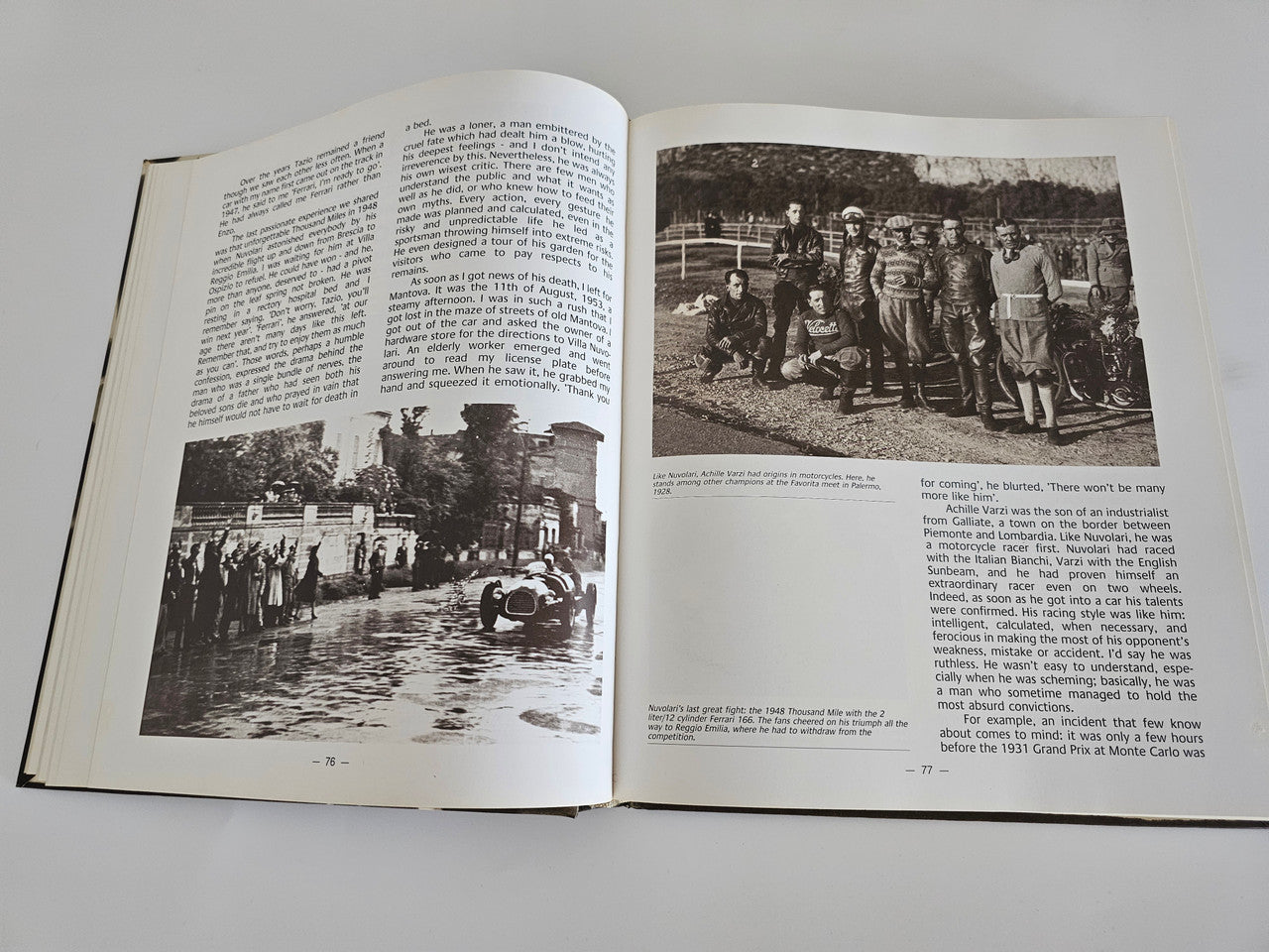 Ferrari racing book open pages with black-and-white race photos and paragraphs.