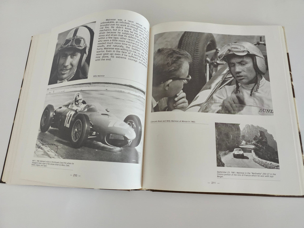 Ferrari racing book open pages with black-and-white racing photos and captions.
