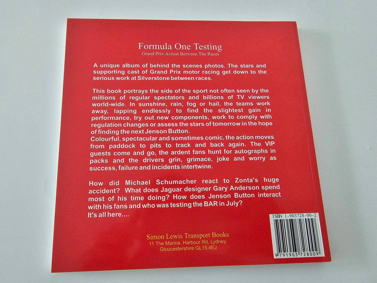 Motorsport photo book back cover with red text panel and publisher details
