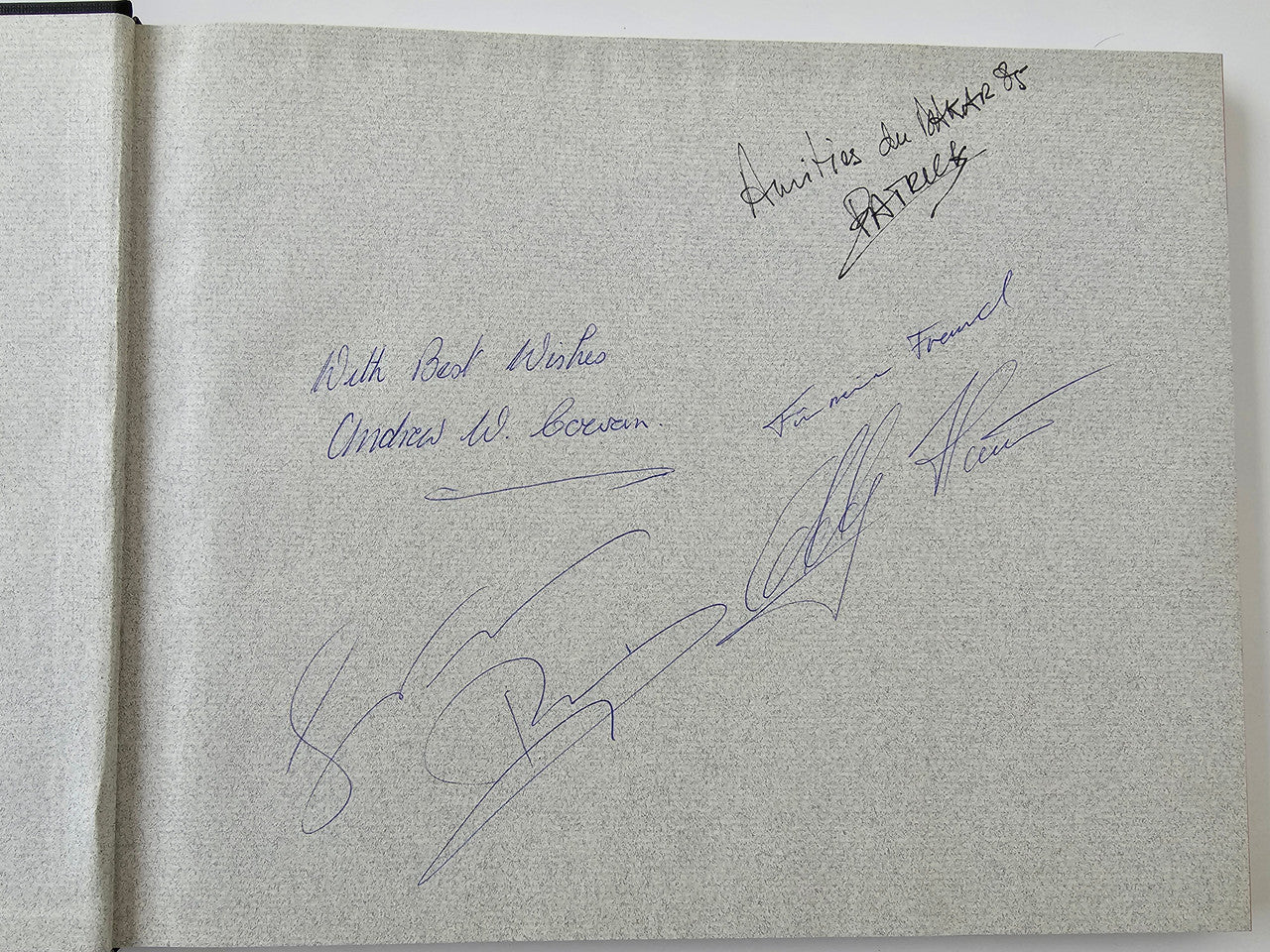 Signed rally program page with blue handwritten autographs on off-white paper