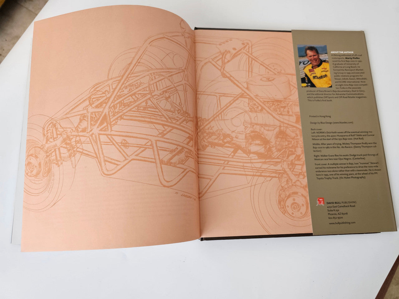 Opened book with peach map line art pages and a right-side author bio panel.