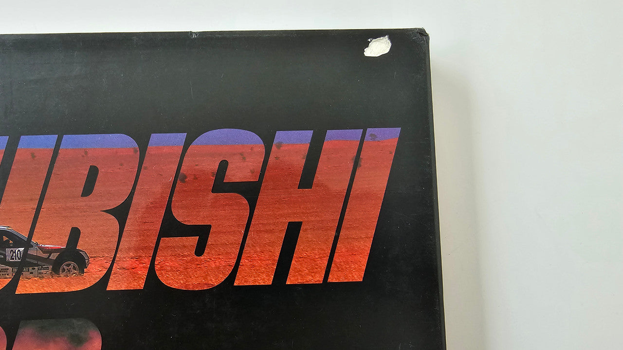 Racing poster or book cover with large MITSUBISHI MOTOR SPORTS text on dark background