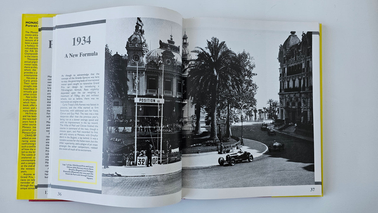 Photo book open to 1934 page with black-and-white street landmark and race car