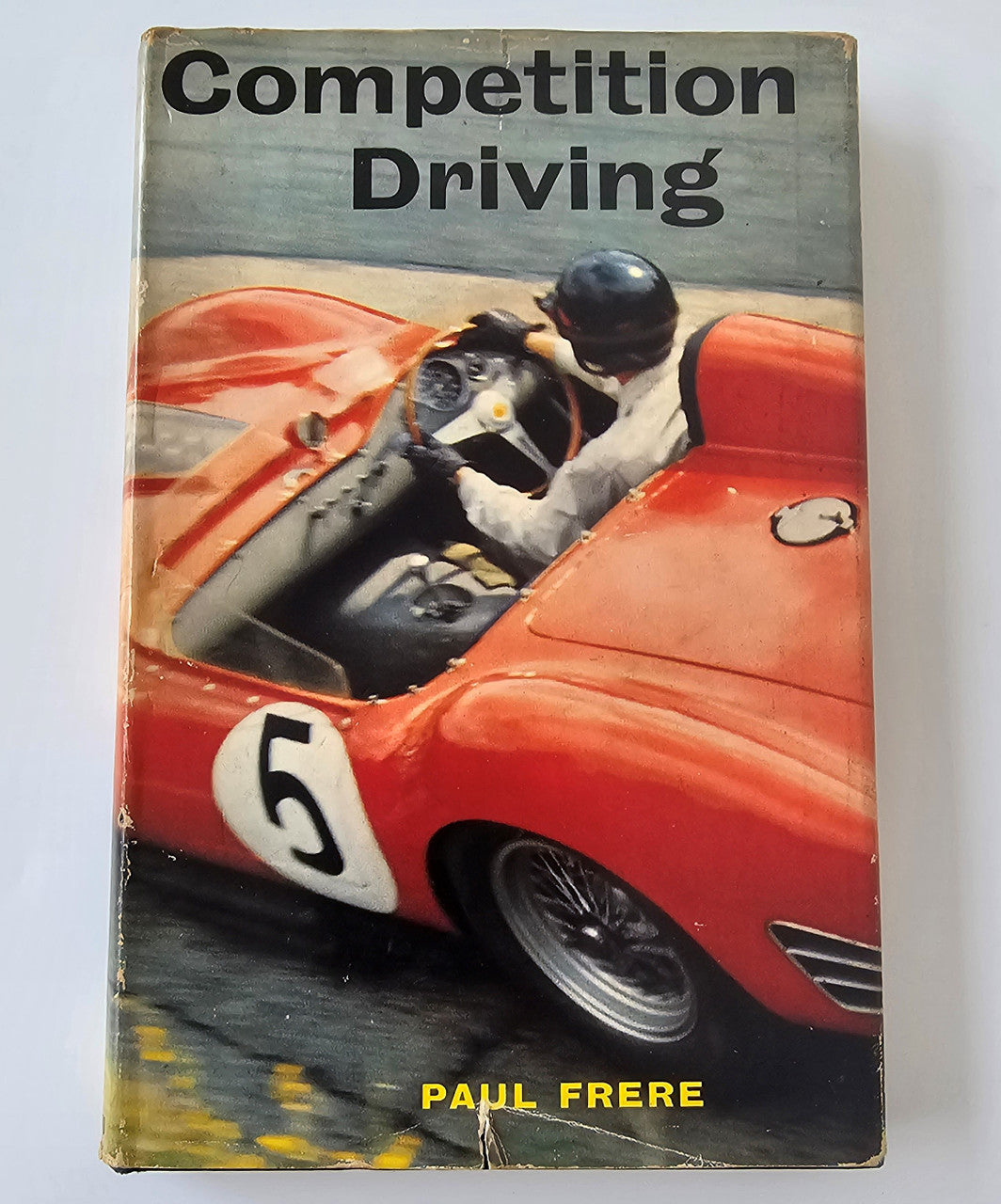Racing book cover with driver in helmet and red race car