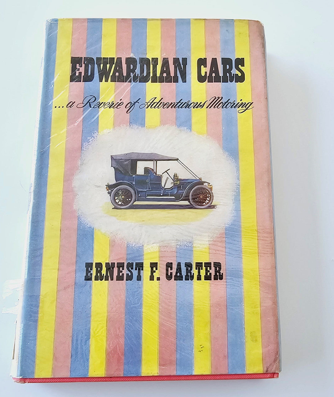 Hardcover book with striped cover, classic car illustration, and author name