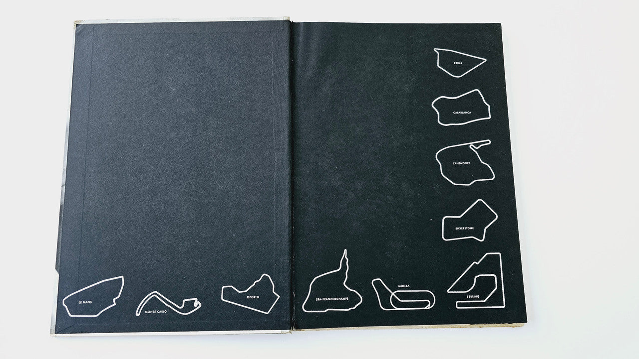 Racedrivers book open showing dark covers with white line-art track diagrams