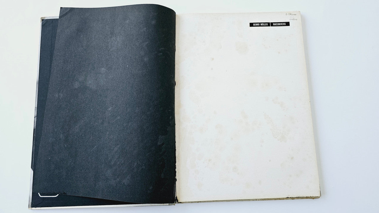 Open vintage photo book with black spine and off-white pages, two-page spread
