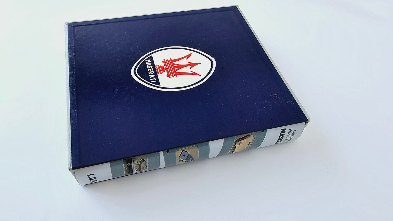 Maserati history book with blue cover and trident logo on top