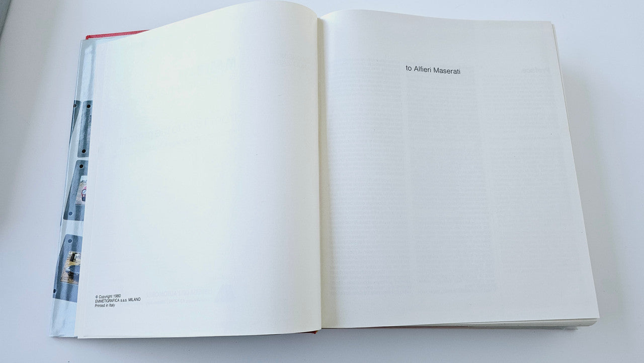 Classic car history book open to a mostly blank page spread