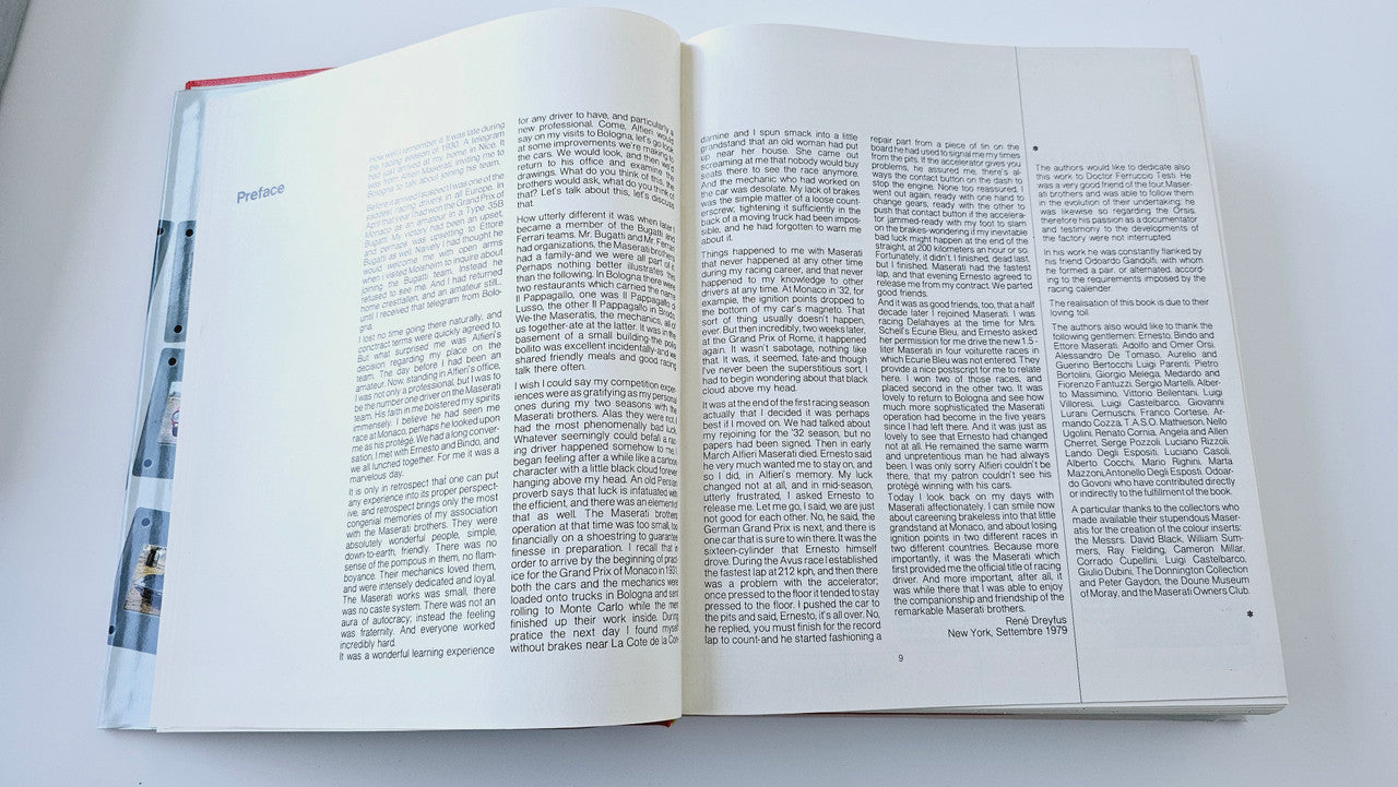 Classic car history book open to dense text pages